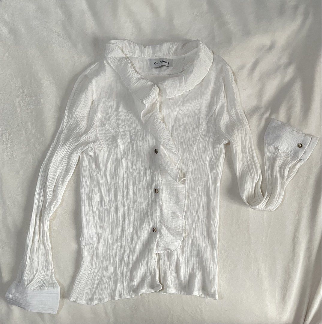 Office / Corporate White Ruffle Blouse Longsleeves (Category: Blouses) located in Mandaluyong City. Submitted by mandmclosey_ (Listing ID 1431659020, Image 2). Description: - RuiMeng white blouse - Ruffled front and collar - Long sleeves with flared cuffs - Button closures - Textured fabric - Measurements: - Length: 22 inches - Width: 13 inches - Sleeves: 22 inches Loc: Mandaluyong City Mode of payment: Gcash only!! Mode of delivery: lalamove/ang