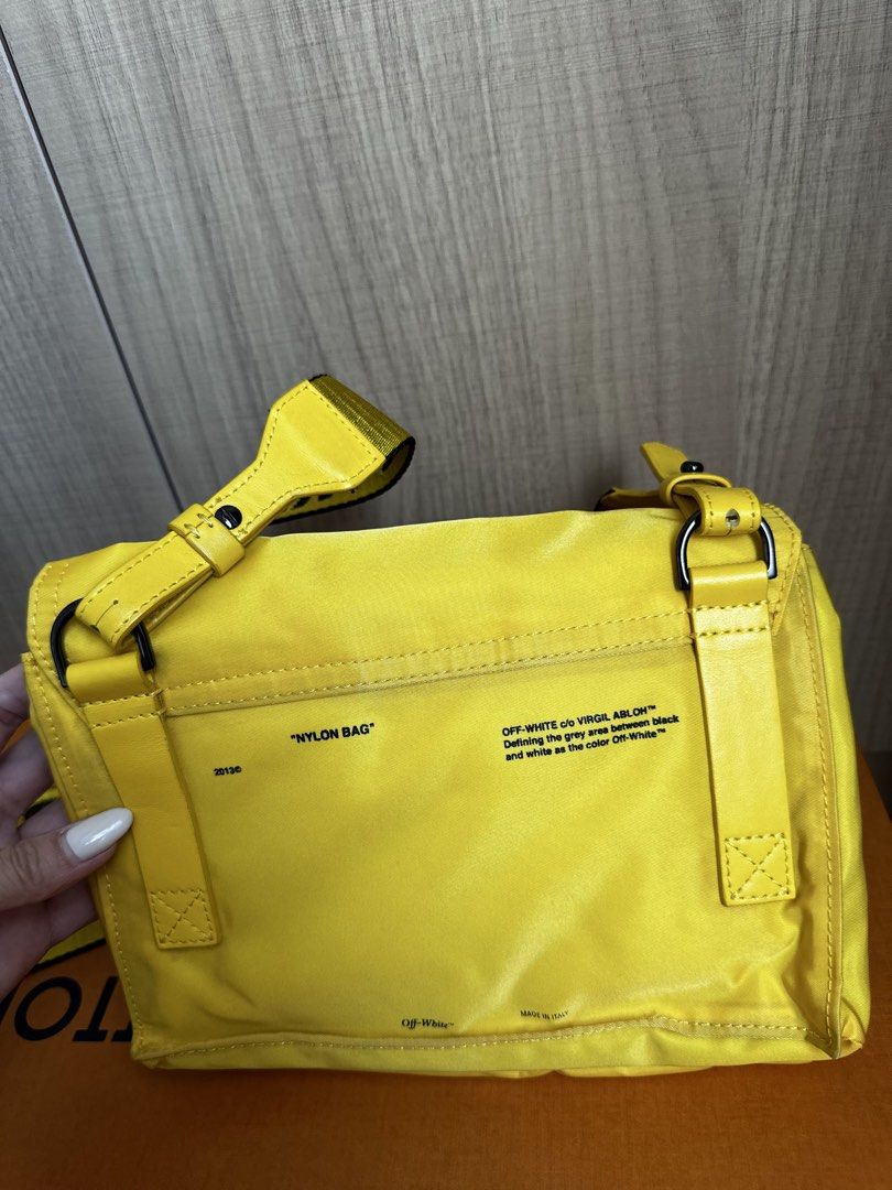 Off-White Nylon Bag (Category: Luxury Bags & Wallets) located in Manila. Submitted by ckaicee9249143 (Listing ID 1431736338, Image 3). Description: - Bright yellow Off-White nylon bag - Detachable shoulder strap - Black clip closure - Multiple interior compartments - Yellow strap with Off-White logo - Yellow interior with light blue lining - "NYLON BAG" printed on the back Lightly used lang, No flaws Decluttering Meet up at Jazz Mall Makati.