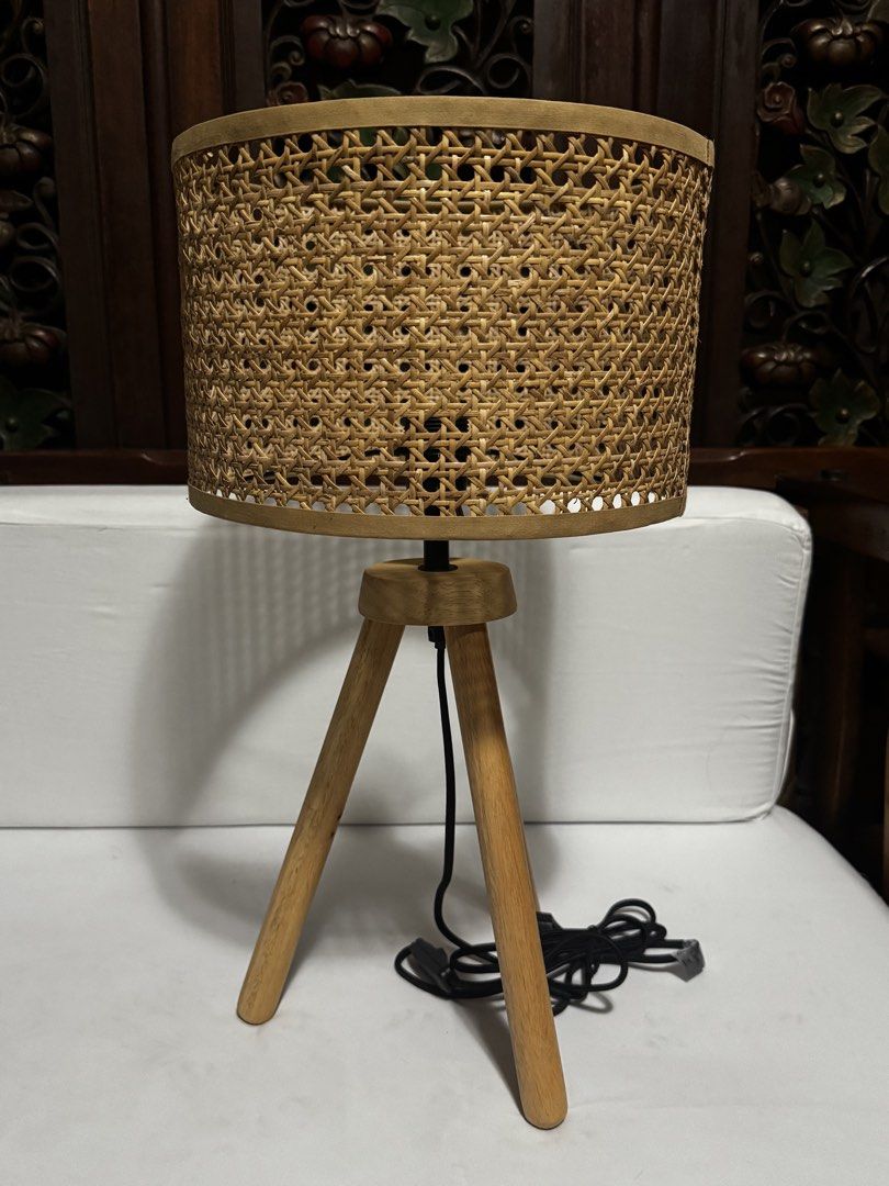 Rattan Shade Tripod Table Lamp (Category: Lighting) located in Quezon City. Submitted by limebasil (Listing ID 1431719909, Image 1). Description: - Woven rattan shade - Wooden tripod base - Neutral color - Provides ambient lighting - Standard electrical cord and socket - Adds natural texture Measurement: Height: 21 inches Diameter: 11.5inches.