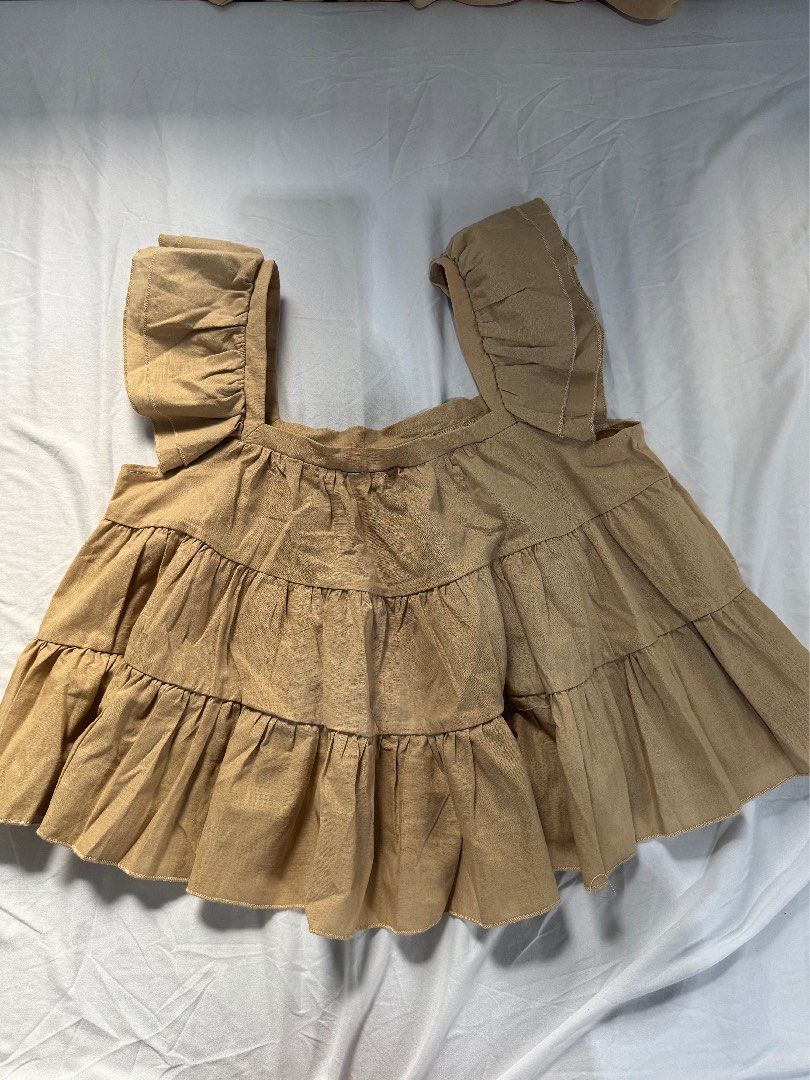 Shein Off-Shoulder Ruffle Top (Category: Blouses) located in Manila. Submitted by raphaelain17296 (Listing ID 1431734972, Image 1). Description: - Shein off-shoulder top - Beige color - Size: L - Design: Layered ruffles - Sleeves: Short - Origin: Made in China.