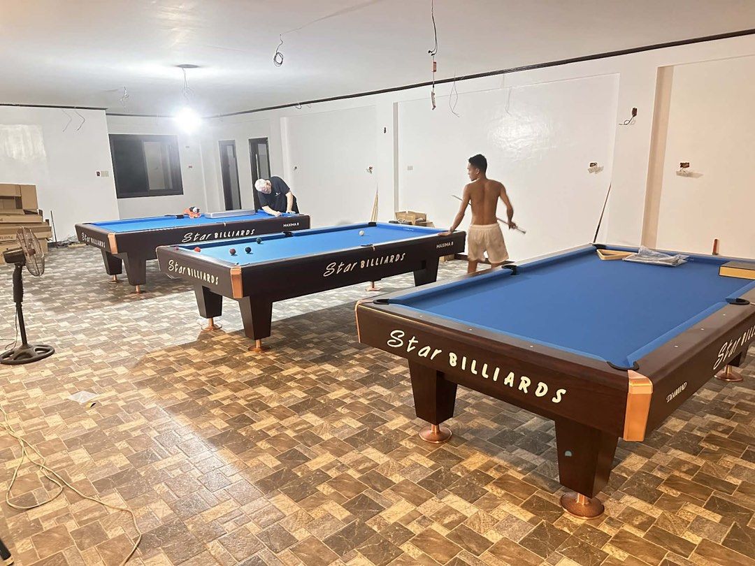 Star Billiards Maxima 8 Diamond Pool Table (Category: Billiards and Bowling) located in Manila. Submitted by zjeven0297378 (Listing ID 1431649069, Image 2). Description: - Three Star Billiards Maxima 8 Diamond pool table - Blue playing surface - Dark brown frame with copper accents - Includes pool cues - Set up in a spacious room with tiled flooring.