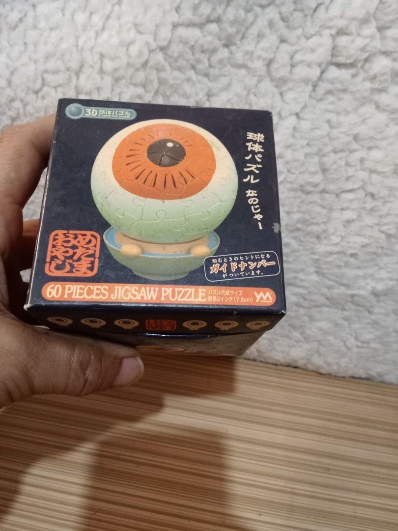 Yanoman 3D Eye Ball Jigsaw Puzzle (Category: Board Games & Puzzles) located in Bocaue. Submitted by marajapansurplus (Listing ID 1431601102, Image 2). Description: - 3D Eye Ball Jigsaw Puzzle - Brand: Yanoman - 60 pieces - Features an eye shape with an orange iris and black pupil - Comes with the original box - Box has Japanese text.