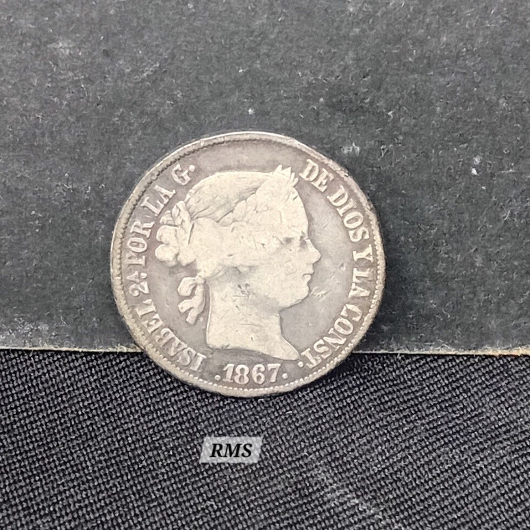 1867 Philippine 20C silver coin, Queen Isabel (Category: Currency) located in Quezon City. Submitted by coinsandbanknotes (Listing ID 1431904540, Image 1). Description: This is a 20 Centavos (or 20 Centimos de Peso) silver coin from the Philippines issued during the Spanish colonial period under Queen Isabella II. Coin Specifications & Identification Issuer: Philippines (Spanish Colony) Monarch: Isabella II (reigned 1833–1868) Value: 20 Centavos 