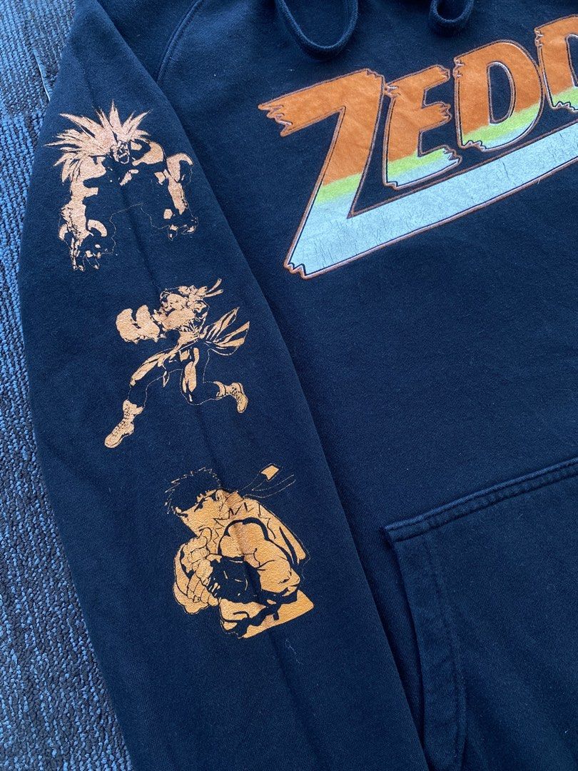 2021 Zedd x Street Fighter (Category: Coats, Jackets and Outerwear) located in Taguig. Submitted by offther4ck (Listing ID 1431903819, Image 3). Description: - Few issues: ( Hairlines on the “Zedd Print, provided pic in the last slide ) - Color Rate 8.5/10 - Width: 22 inches - Length: 28 inches .