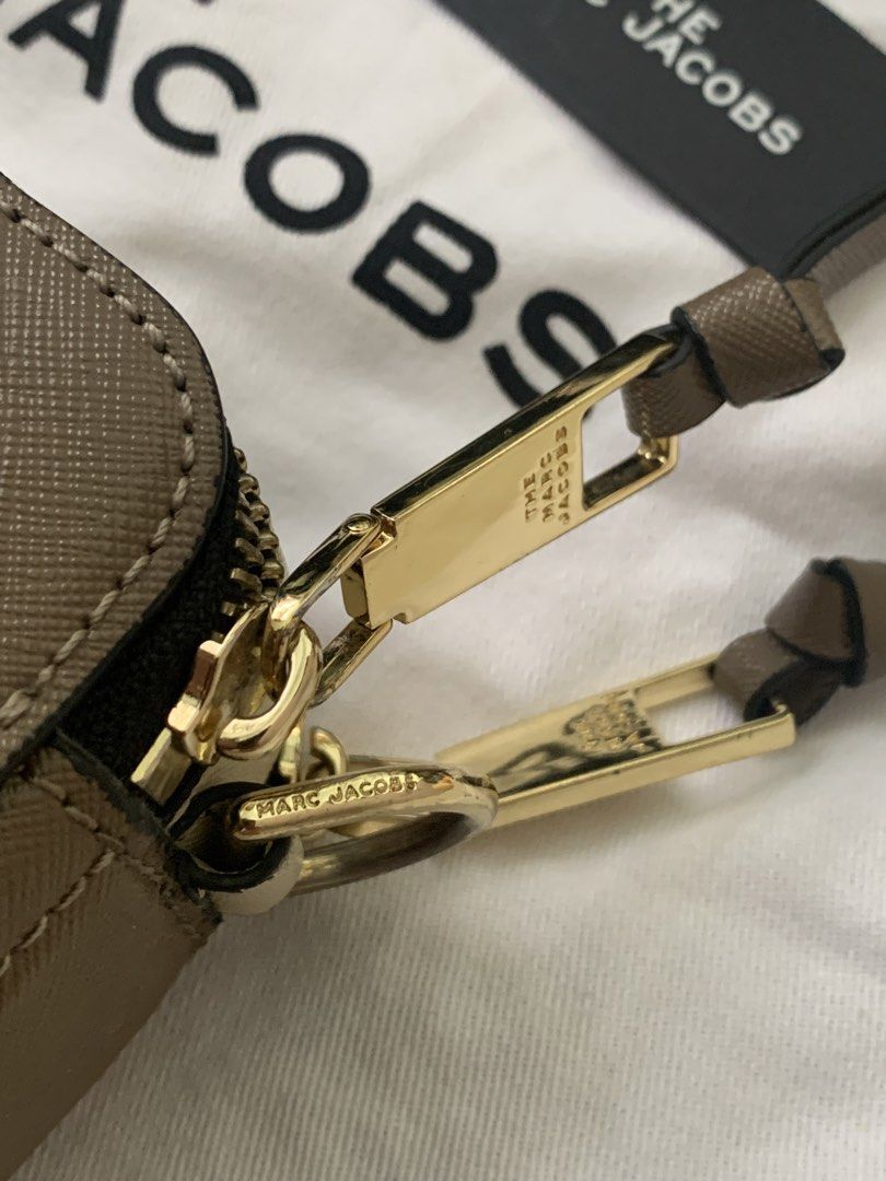 Authentic Marc Jacobs Snapshot Camera Bag (Category: Luxury Bags & Wallets) located in Manila. Submitted by ilovepreloved.thine (Listing ID 1431839360, Image 2). Description: - Authentic Marc Jacobs Snapshot camera bag - Gold-tone 'J' logo and hardware - Detachable and adjustable logo strap - Dual-compartment design with zip closure - Includes dust bag, tags, and wrist strap - Black interior lining - Made in Vietnam - Conditon: 9/10 just signs of