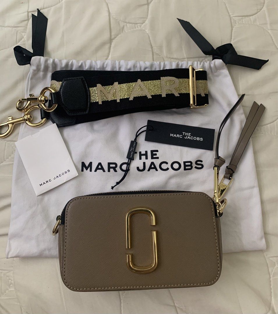 Authentic Marc Jacobs Snapshot Camera Bag (Category: Luxury Bags & Wallets) located in Manila. Submitted by ilovepreloved.thine (Listing ID 1431839360, Image 1). Description: - Authentic Marc Jacobs Snapshot camera bag - Gold-tone 'J' logo and hardware - Detachable and adjustable logo strap - Dual-compartment design with zip closure - Includes dust bag, tags, and wrist strap - Black interior lining - Made in Vietnam - Conditon: 9/10 just signs of