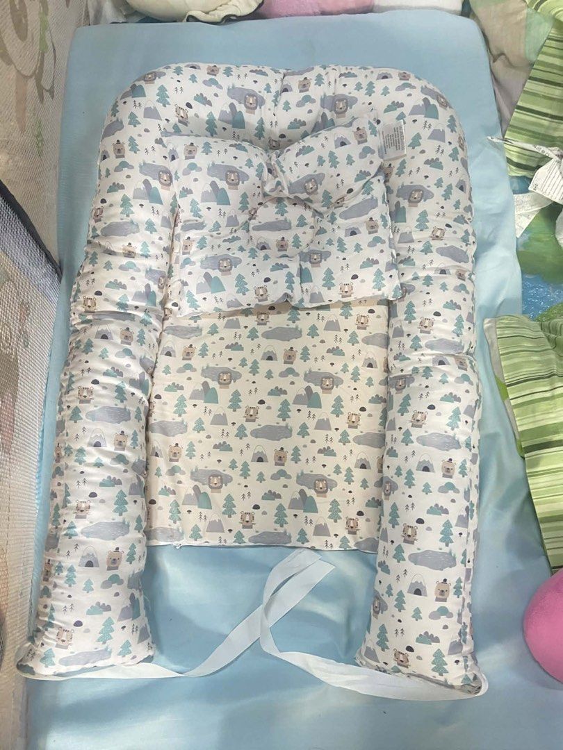 Baby Nest (Category: Cots & Cribs) located in Quezon City. Submitted by nathaliedychiao (Listing ID 1431835298, Image 1). Description: - Adorable baby nest with bear and tree pattern. - Soft, padded design for comfort. - Raised sides for added security. - Adjustable tie to customize size. - Ideal for newborns and infants. - Creates a cozy and comfortable sleep space..