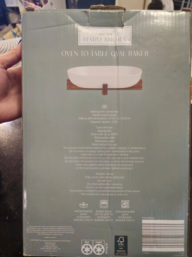 Baking/Cooking Bakeware (Category: Bakeware) located in Santa Rosa. Submitted by fairygalesclothestation25 (Listing ID 1431977226, Image 2). Description: The image shows the packaging for a Crofton Festive Kitchen Oven to Table Oval Baker. This product features a glazed stoneware baker paired with an FSC Certified Acacia wood stand. Microwave Safe: Only the ceramic baker is microwave safe. Oven Safe: The ceramic baker can withstand temperatures u