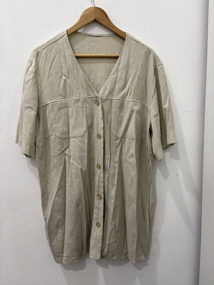 Beige Button-Up Top (Category: Blouses) located in Sungai Buloh. Submitted by shyra_91 (Listing ID 1431915321, Image 3). Description: - Beige button-up shirt - V-neck design - Short sleeves - Two front pockets - Button-down closure - Textured fabric - Relaxed fit.