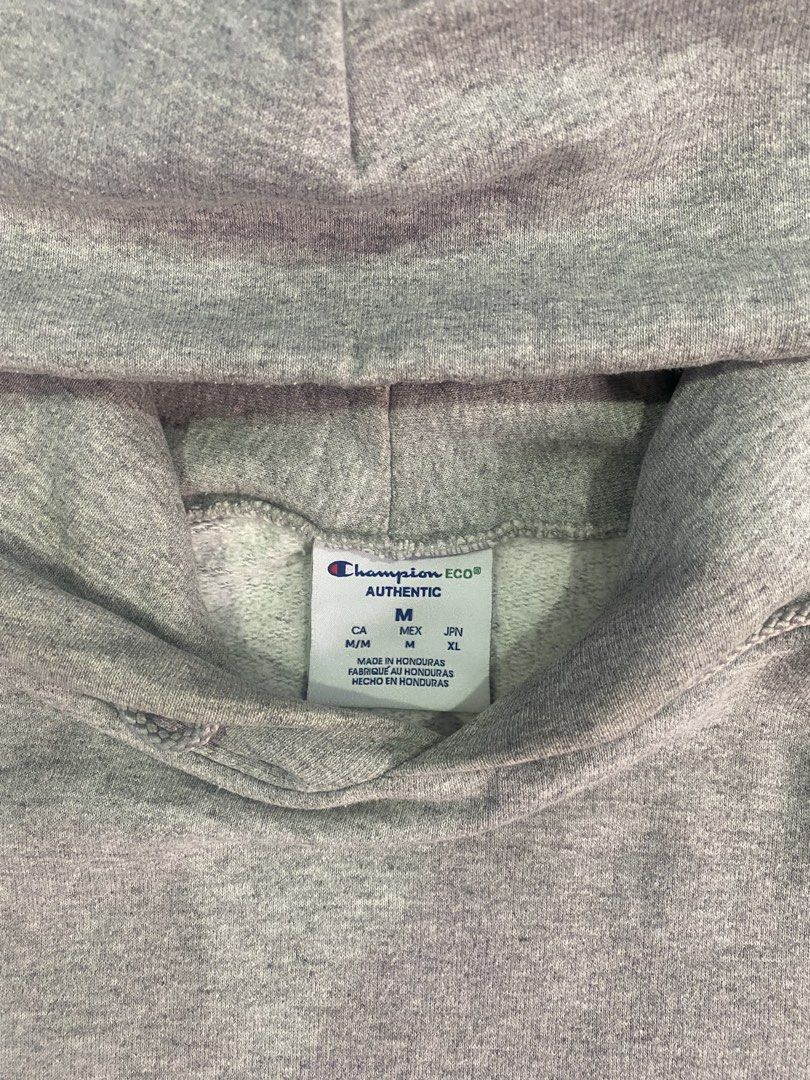 Champion Hoodie - Gray - Medium (Category: Hoodies) located in Quezon City. Submitted by denjayc (Listing ID 1431828804, Image 3). Description: - Champion hoodie - Size: M - Color: Gray - Features: Hood and kangaroo pocket - Condition: Stain on front pocket and small hole near pocket - Logo: Champion logo on left sleeve - Made in Honduras.