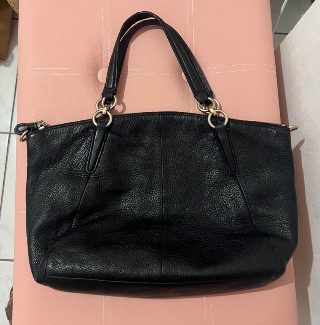 Coach Black Leather Handbag (Category: Luxury Bags & Wallets) located in Quezon City. Submitted by shop8holic (Listing ID 1431816275, Image 2). Description: - Black Coach handbag - Gold-tone hardware - Zip closure - Dual top handles - Detachable shoulder strap - Textured leather - Dark blue fabric lining - Includes Coach leather tag.