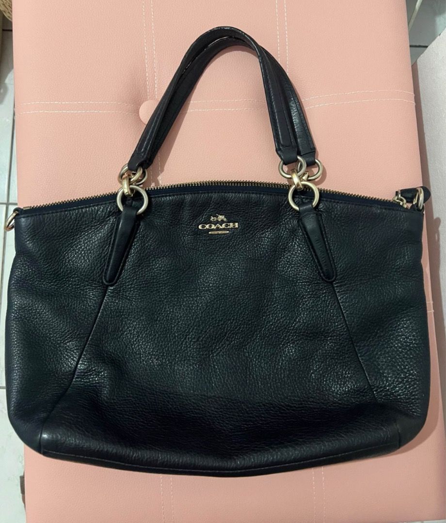 Coach Black Leather Handbag (Category: Luxury Bags & Wallets) located in Quezon City. Submitted by shop8holic (Listing ID 1431816275, Image 1). Description: - Black Coach handbag - Gold-tone hardware - Zip closure - Dual top handles - Detachable shoulder strap - Textured leather - Dark blue fabric lining - Includes Coach leather tag.