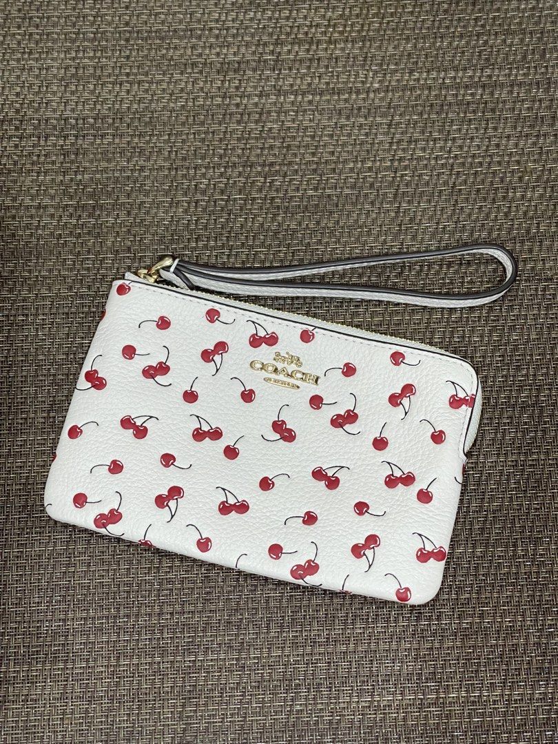 Coach Cherry Print White Wristlet (Category: Luxury Bags & Wallets) located in Quezon City. Submitted by mimi_declutters (Listing ID 1431927387, Image 1). Description: - Coach wristlet - Cherry print on white - Gold-toned zipper - Wrist strap included - Features the Coach logo - AUTHENTICITY GUARANTEED SLIGHTLY NEGOTIABLE.