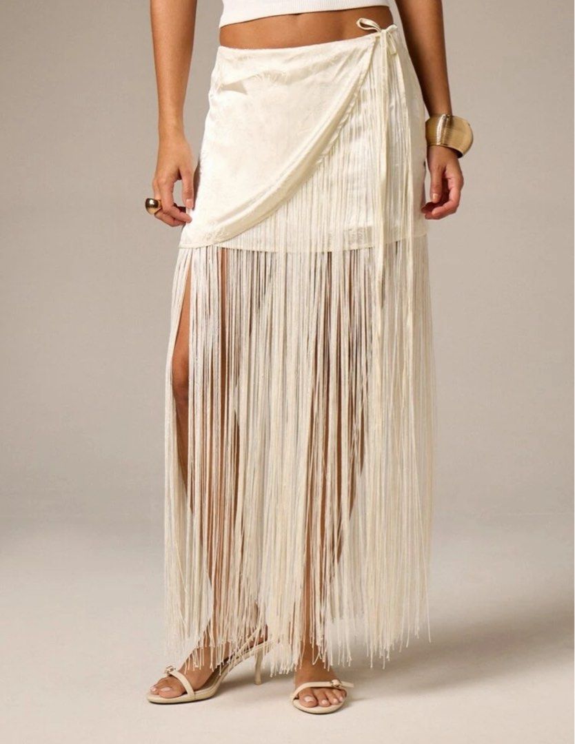 Cream Fringe Wrap Skirt (Category: Skirts) located in Muntinlupa City. Submitted by stephschrber (Listing ID 1431835962, Image 1). Description: - Cream-colored wrap skirt - Fringe detailing - Wrap design with tie closure - Subtle fabric pattern.