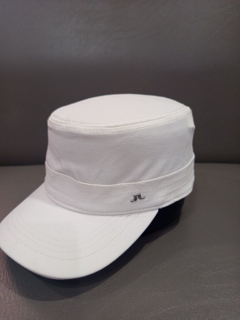 J. Lindeberg White Cap (Category: Caps & Hats) located in Davao. Submitted by vaness041421 (Listing ID 1431961413, Image 1). Description: - J. Lindeberg white cap - Features a flat brim and structured crown - Brand logo on the side - Interior lining with brand name - Made of smooth, possibly synthetic material - Clean, minimalist design.