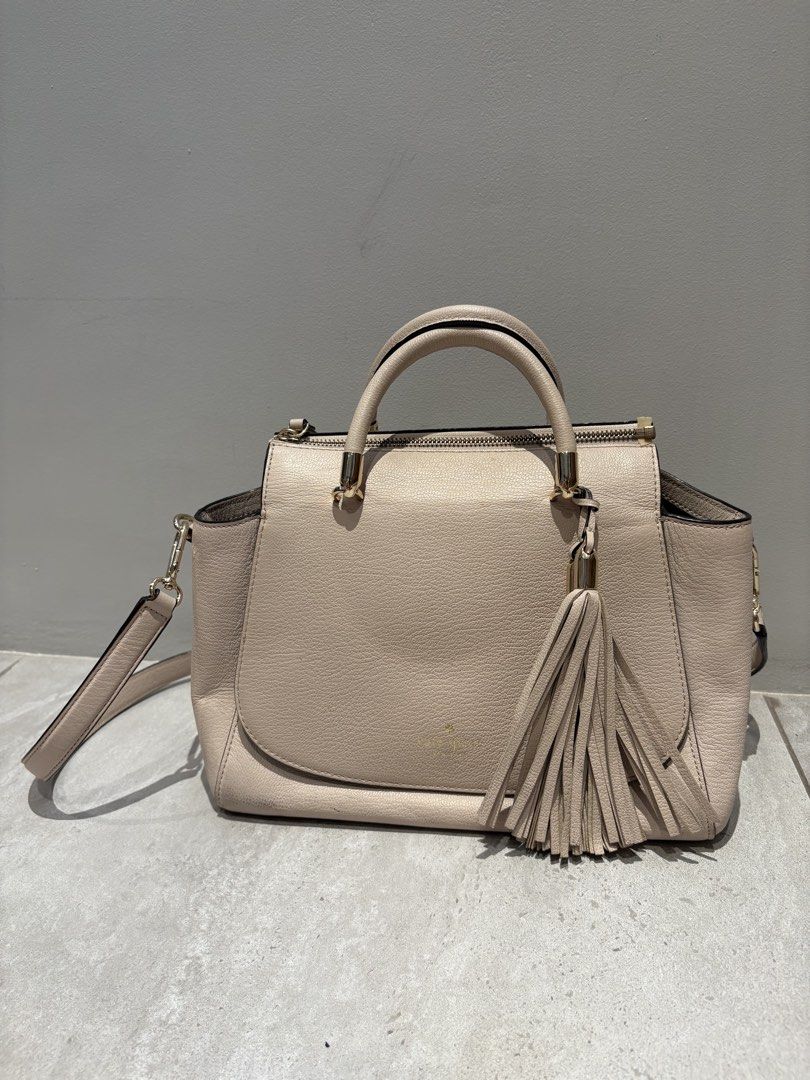 Kate Spade Satchel Handbag (Category: Luxury Bags & Wallets) located in Makati City. Submitted by ng2026 (Listing ID 1431857503, Image 2). Description: - Authentic Kate Spade satchel handbag - Barely used, only stored - Beige exterior - Top handle and detachable shoulder strap - Stylish tassel detail - Secure zip closure - Patterned interior lining - Includes Kate Spade card - Protective metal feet at the bottom.
