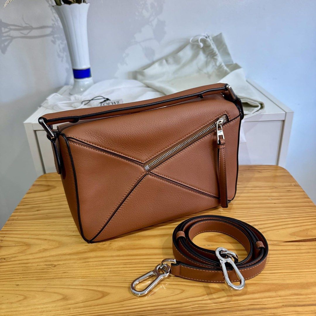 Loewe Puzzle Bag Small (Category: Luxury Bags & Wallets) located in Taguig. Submitted by ceegeedee (Listing ID 1431954664, Image 2). Description: - Loewe Puzzle Bag in brown - Top handle and detachable shoulder strap - Unique geometric design - Zipper closure - Multiple interior compartments - Includes dust bag - Perfect for everyday use.
