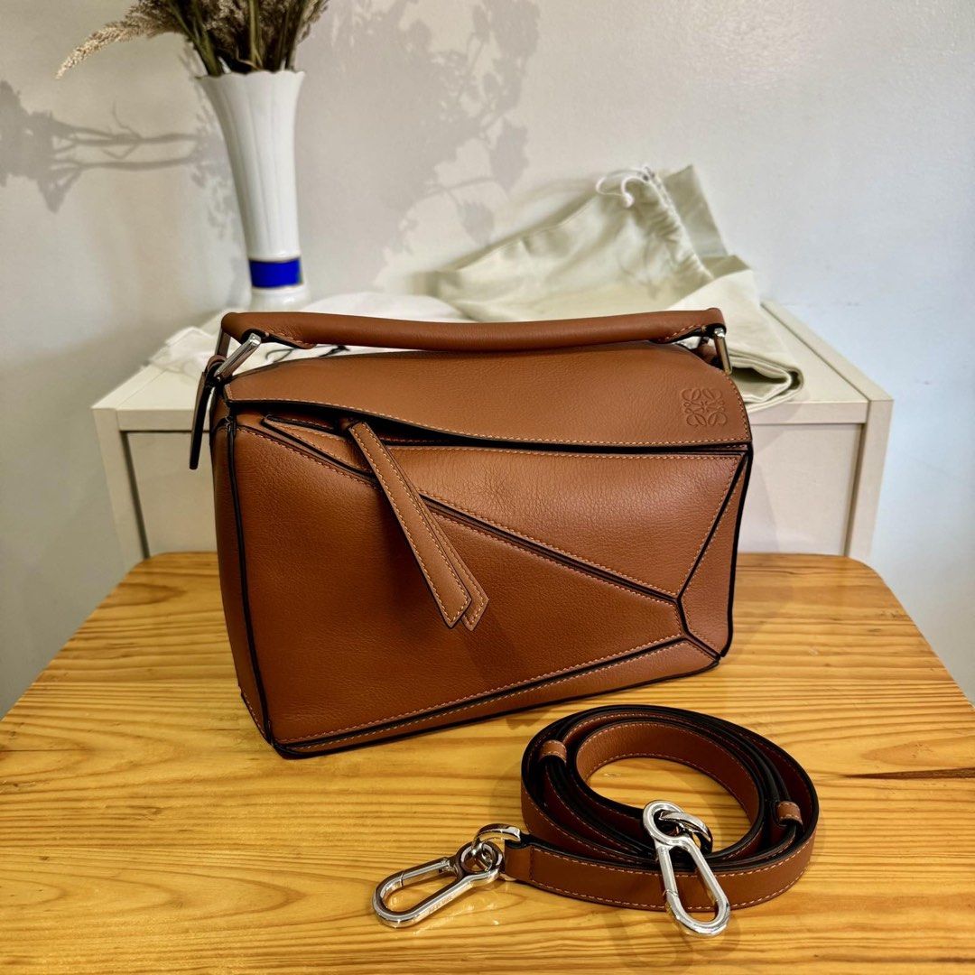 Loewe Puzzle Bag Small (Category: Luxury Bags & Wallets) located in Taguig. Submitted by ceegeedee (Listing ID 1431954664, Image 1). Description: - Loewe Puzzle Bag in brown - Top handle and detachable shoulder strap - Unique geometric design - Zipper closure - Multiple interior compartments - Includes dust bag - Perfect for everyday use.