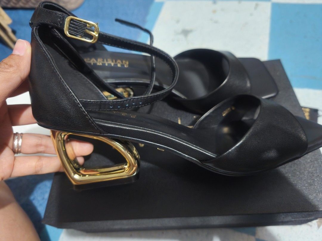 Parisian Limited Black Sandals (Category: Flats & Sandals) located in Caloocan City. Submitted by yyybba (Listing ID 1431844496, Image 1). Description: Elegant black sandals from Parisian Limited. Features a stylish design with a gold-colored heel. Includes an ankle strap with a buckle for a secure fit. Comes with the original box and packaging. The sandals appear unworn..