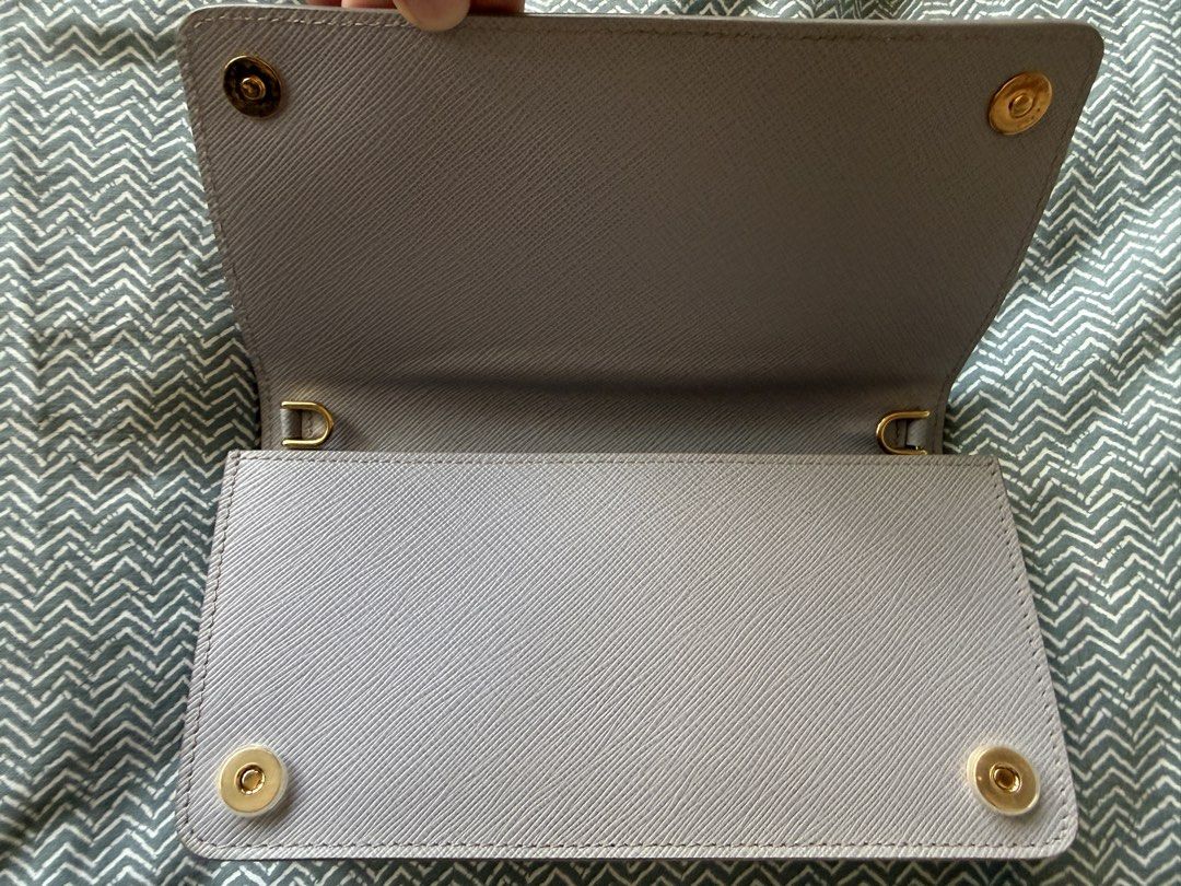 Prada Wallet on Chain w/ Card & Entrupy (Category: Luxury Bags & Wallets) located in Talisay. Submitted by justgeeeee (Listing ID 1431871659, Image 3). Description: - Authentic Prada Mini Bandolier Wallet - Light purple, Gold Hardware, Detachable Strap - Comes with original dust bag, card and entrupy Can fit Iphone Promax Can be worn 4 ways - crossbody, shoulder bag, kili bag, clutch/long wallet.