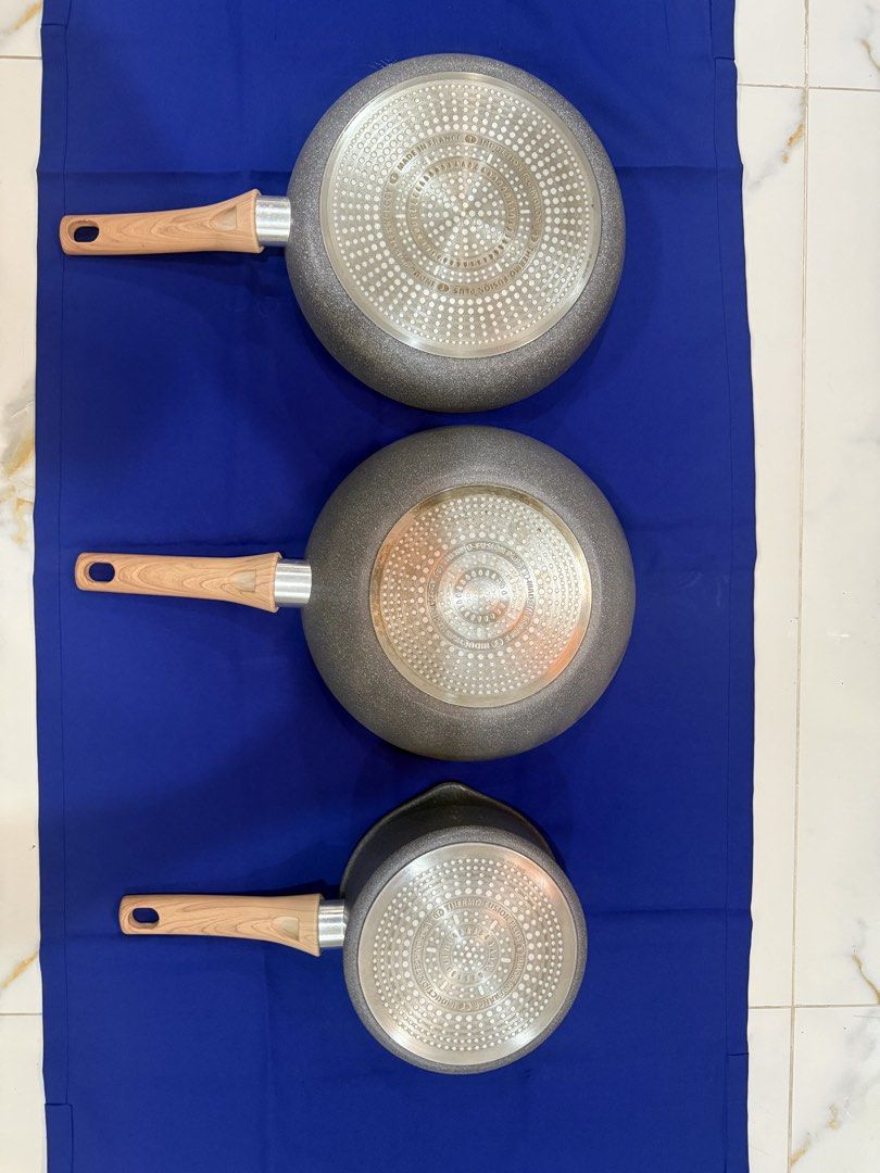T-fal Non-Stick Fry Pan Set (Category: Cookware & Accessories) located in Marikina City. Submitted by dfsapo (Listing ID 1431811187, Image 2). Description: - T-fal non-stick pan set - Includes: - Small saucepan (approx. 14cm diameter) - Medium wok-style pan - Large fry pan (approx. 28cm diameter) - Stylish wooden-look handles - Attractive speckled gray interior - Patterned bottom design.