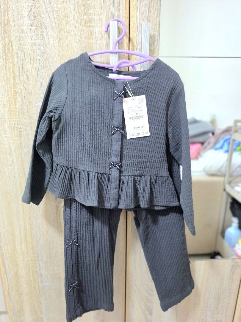 ZARA Kids Top and Pants Set (Category: Babies & Kids Fashion) located in Angono. Submitted by declothering.ph (Listing ID 1431810984, Image 1). Description: - Ribbed fabric set - Long-sleeved top with ruffled hem - Bow details on top and pants - Button-up front on top - Matching pants included - Stylish and comfortable.