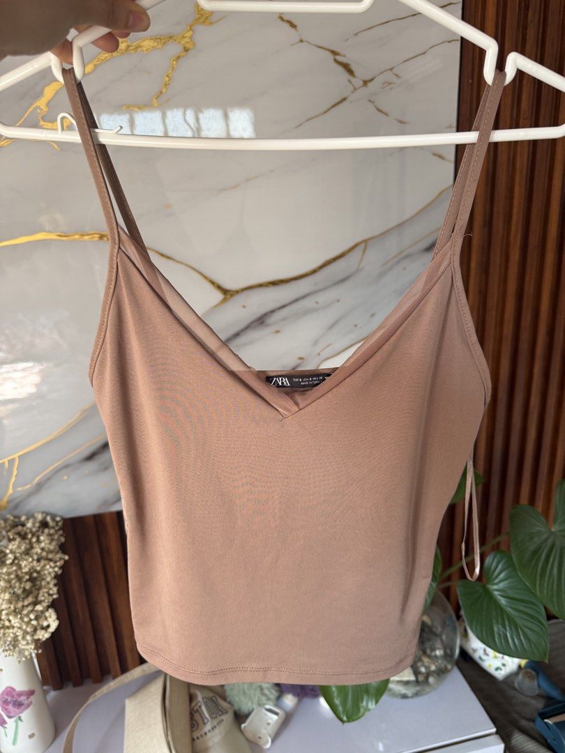 Zara V-neck Cami Top (Category: Sleeveless) located in Marikina City. Submitted by declutter_keni24 (Listing ID 1431802857, Image 1). Description: - Zara cami top - Size: S - Features a V-neck and spaghetti straps - Color: Neutral brown - Made in Turkey - Perfect for dressing up or down.