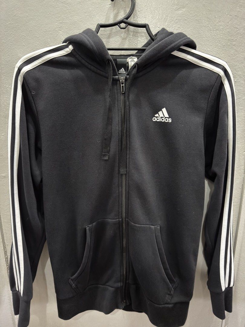 Adidas Black Hoodie (Category: Coats, Jackets and Outerwear) located in Pasig City. Submitted by bruclutter (Listing ID 1432052313, Image 2). Description: Black Adidas hoodie with white stripes on the sleeves. -full zip closure, a hood, and two front pockets. The Adidas logo is visible on the chest. The size is XS. Original. rarely used. condition 9/10.