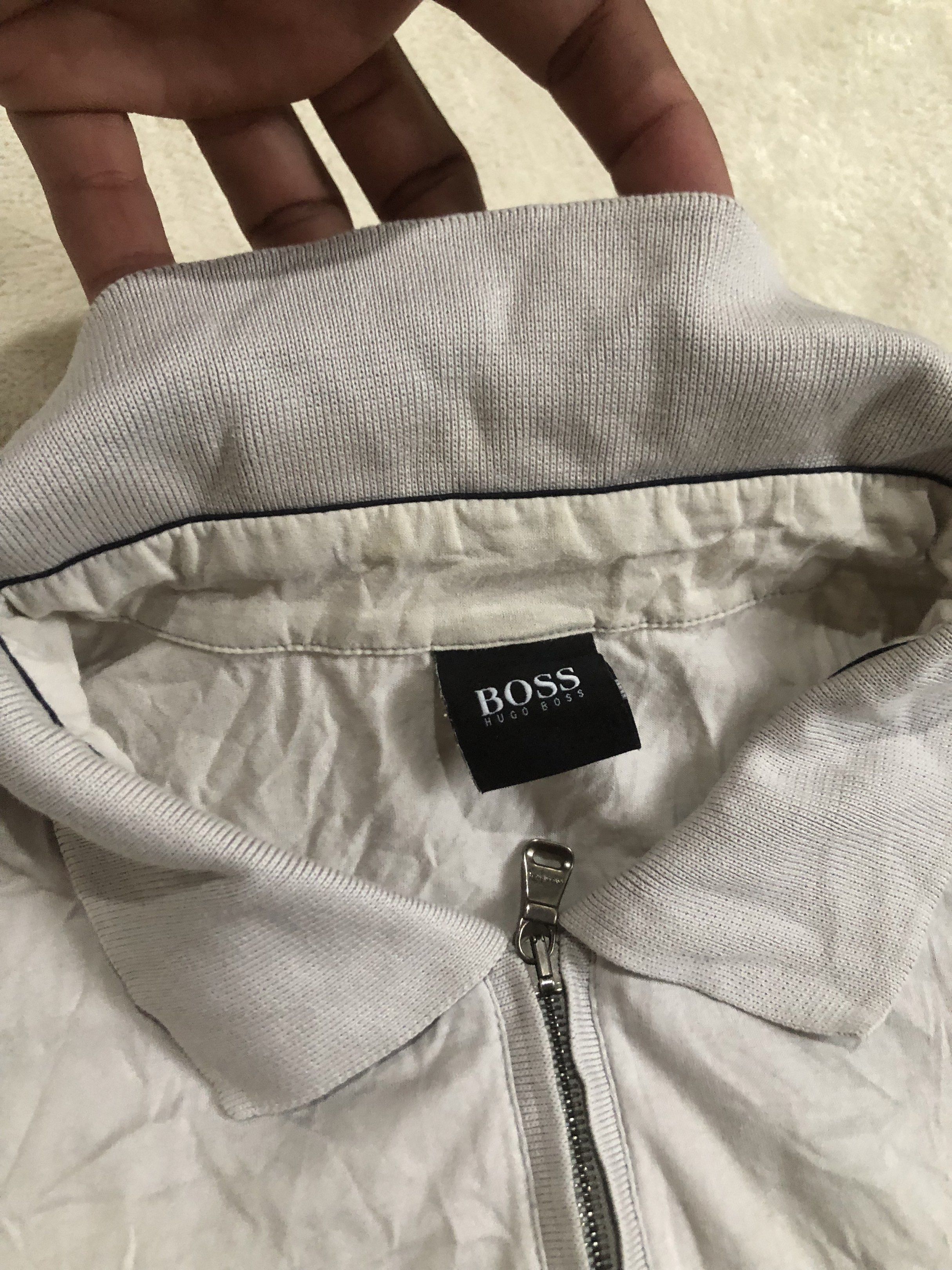 BOSS Hugo Boss Polo Shirt (Category: Tshirts & Polo Shirts ) located in Binalbagan. Submitted by kianbenedict024 (Listing ID 1432048601, Image 2). Description: - BOSS Hugo Boss polo shirt - Color: Gray - Features: Zip-up collar, short sleeves - Design: BOSS logo detail - Origin: Made in Romania - Size: Not specified.