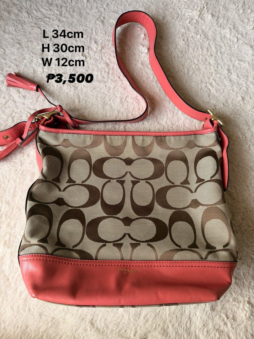 Coach Shoulder Bag with Pink Accents (Category: Luxury Bags & Wallets) located in Pasig City. Submitted by btchelor01 (Listing ID 1432074068, Image 1). Description: - Coach shoulder bag - Signature pattern - Pink strap and base - Gold-tone hardware - Dimensions: 34cm (L) x 30cm (H) x 12cm (W) - Features tassel detail - Coach logo visible.