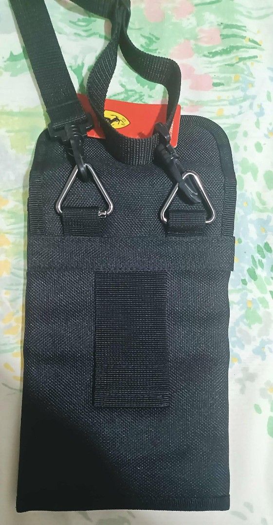 Ferrari Crossbody Bag (Category: Luxury Bags & Wallets) located in Angeles City. Submitted by victoria_l. (Listing ID 1432067247, Image 2). Description: Black Ferrari crossbody bag with a detachable strap. Features the Ferrari logo on the front. The interior includes multiple compartments, including a zippered pocket, a clear pocket, and several card slots. Comes with a tag..