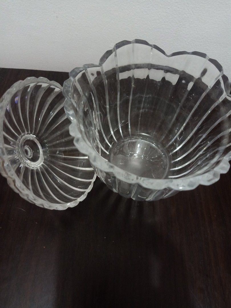 Glass Candy jar (Category: Other Kitchenware & Tableware) located in Las Pinas. Submitted by the_recycle_shop (Listing ID 1432136322, Image 2). Description: - Elegant glass candy dish with matching lid - Features a scalloped edge design - Vertical ribbed detailing on bowl and lid - Lid has a round knob for easy handling - Ideal for serving candies, nuts, or small treats - A decorative piece for any table setting.