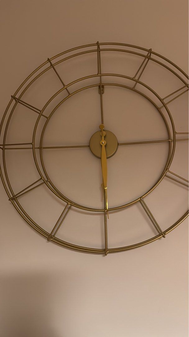 Gold Metal Wall Clock (Category: Clocks) located in Singapore. Submitted by laibakhan55874 (Listing ID 1432063243, Image 1). Description: - Elegant gold metal wall clock - Minimalist circular design - Features Roman numeral hour markers - Adds sophistication to any room - Ready to hang.