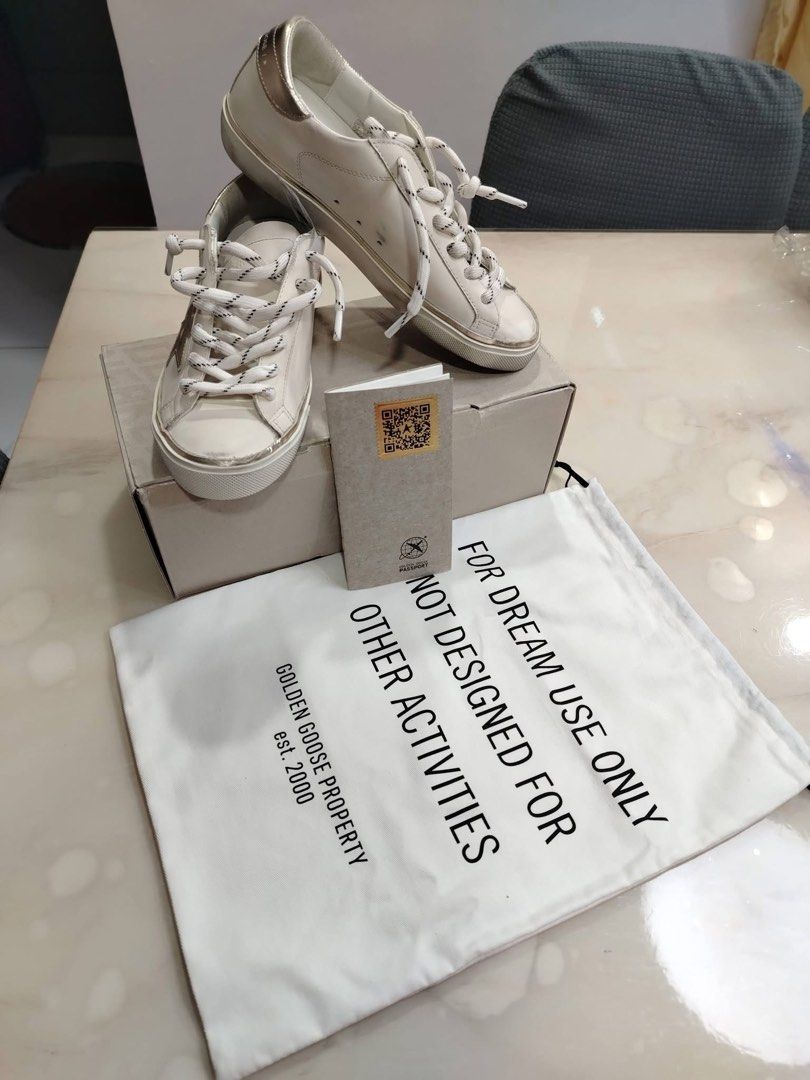 Golden Goose Superstar Sneakers (Category: Sneakers) located in Quezon City. Submitted by lovequeenph (Listing ID 1432055794, Image 1). Description: - Authentic Golden Goose Superstar sneakers - White leather upper - Gold-colored heel tab and signature star - Includes original box, dust bag, and authentication card - White laces with black accents - Dust bag text: "FOR DREAM USE ONLY NOT DESIGNED FOR OTHER ACTIVITIES GOLDEN GOOSE PROPERTY est. 20