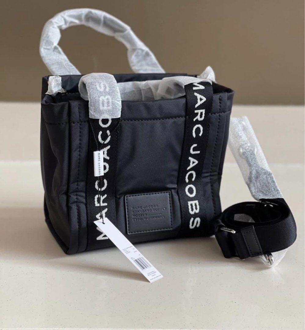 Marc Jacobs Mini Traveler Tote Bag Black (Category: Luxury Bags & Wallets) located in Caloocan City. Submitted by Roowchelly (Listing ID 1432163608, Image 1). Description: - Brand new Marc Jacobs Mini Traveler Tote Bag - Color: Black - Features brand name on straps - Includes a detachable shoulder strap - Comes with original tag - Rectangular shape with top handle - Unused condition.