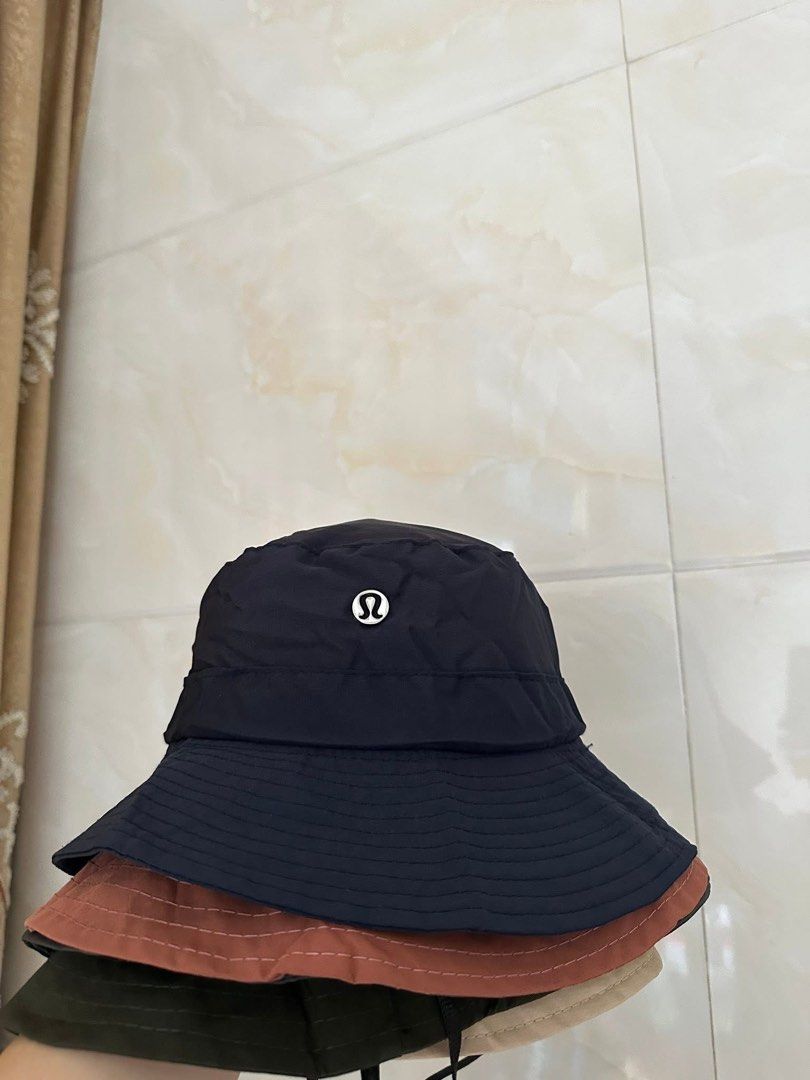Packable Bucket Hat (Category: Hats & Beanies) located in Valenzuela. Submitted by shopwithmika (Listing ID 1432152791, Image 3). Description: - Packable bucket hats - Folds into a compact pouch - Available Colors: - Black - Navy - Olive Green - Beige - Rust - Features a small logo (Alo or Lululemon).