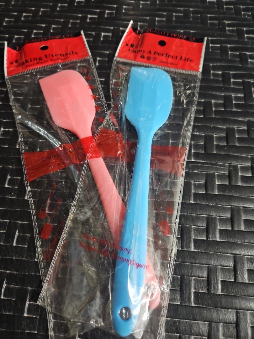 Silicone Spatula (Category: Bakeware) located in Manila. Submitted by just_about_anything (Listing ID 1432128548, Image 1). Description: - Set includes two silicone spatulas: one blue, one pink. - Brand new, in original packaging. - Designed for baking and cooking. - Each spatula has a convenient hole for hanging..