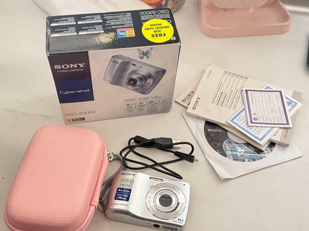 Sony Cybershot DSC-S3000 Digital Camera (Category: Cameras) located in Manila. Submitted by keirab091090410 (Listing ID 1432096509, Image 2). Description: - Sony Cybershot DSC-S3000 - 10.1 Megapixels - 4x Optical Zoom - 28mm Wide-Angle Lens - Includes: Original Box, Manuals, USB Cable, Pink Carrying Case - Features: Smile Shutter, Steady Shot - Color: Silver.