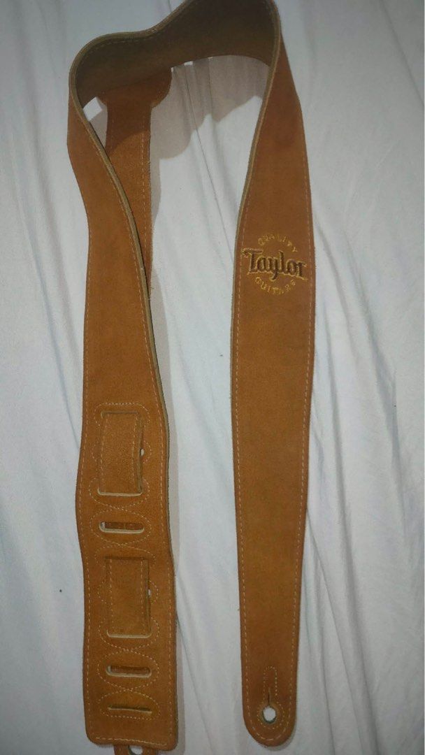 Taylor Guitar Strap - Genuine Leather (Category: Musical Instruments) located in Dagupan City. Submitted by oompph (Listing ID 1432088227, Image 1). Description: - Genuine leather guitar strap from Taylor Guitars - Tan suede finish - Features Taylor Guitars logo embroidery - Adjustable length - Made in Canada - Classic design - Suitable for various guitar types.