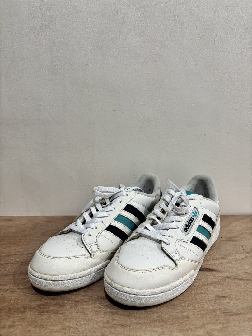 Adidas Continental 80s White Sneakers (Category: Sneakers) located in Bacoor. Submitted by palmroot (Listing ID 1432245033, Image 1). Description: - Adidas Continental 80s - White with teal and black stripes - Adidas logo on tongue and heel - Size: US 10 / UK 9.5 / FR 44 / JP 285 - Made in Indonesia - White laces and sole - has fabric rubs on inner later from black socks but kept clean and minimally used.