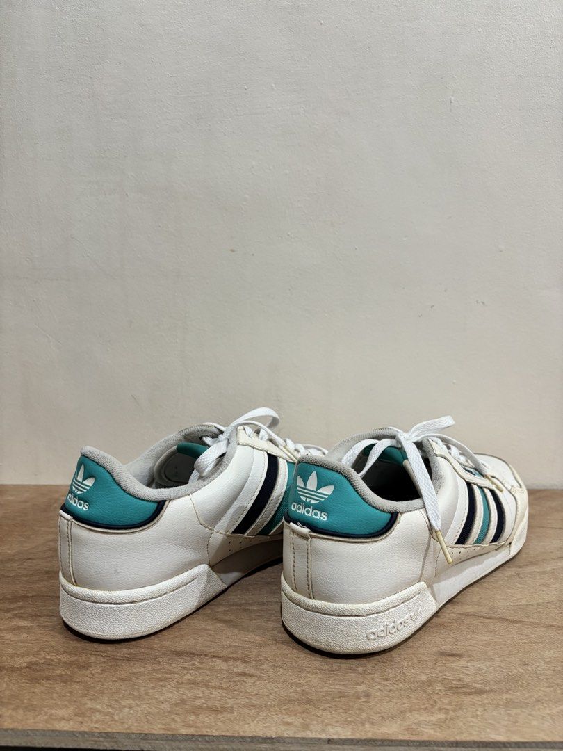 Adidas Continental 80s White Sneakers (Category: Sneakers) located in Bacoor. Submitted by palmroot (Listing ID 1432245033, Image 2). Description: - Adidas Continental 80s - White with teal and black stripes - Adidas logo on tongue and heel - Size: US 10 / UK 9.5 / FR 44 / JP 285 - Made in Indonesia - White laces and sole - has fabric rubs on inner later from black socks but kept clean and minimally used.