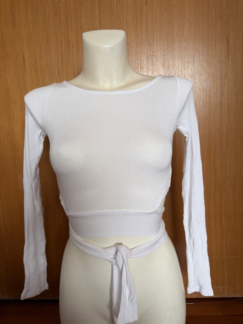 Alo White Long Sleeve Wrap Top (Category: Activewear) located in Singapore. Submitted by veganyogi (Listing ID 1432174661, Image 1). Description: White long sleeve wrap top from Alo. Features a ribbed texture and a tie-waist design. Perfect for layering or wearing on its own. Great for yoga or casual wear..