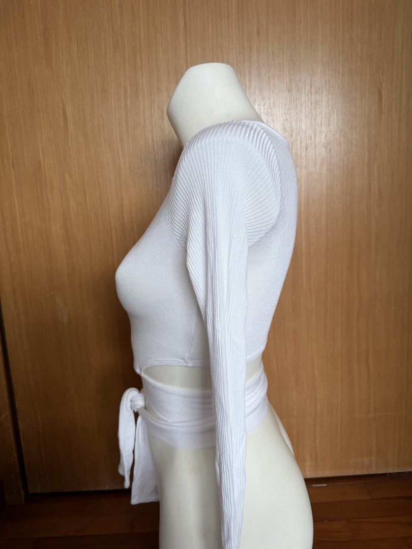 Alo White Long Sleeve Wrap Top (Category: Activewear) located in Singapore. Submitted by veganyogi (Listing ID 1432174661, Image 3). Description: White long sleeve wrap top from Alo. Features a ribbed texture and a tie-waist design. Perfect for layering or wearing on its own. Great for yoga or casual wear..