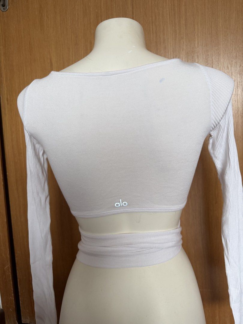 Alo White Long Sleeve Wrap Top (Category: Activewear) located in Singapore. Submitted by veganyogi (Listing ID 1432174661, Image 2). Description: White long sleeve wrap top from Alo. Features a ribbed texture and a tie-waist design. Perfect for layering or wearing on its own. Great for yoga or casual wear..