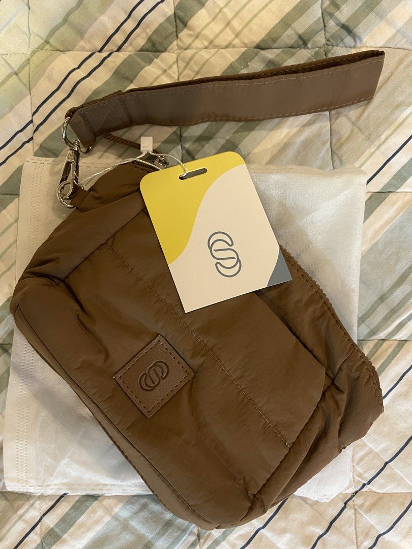 Brown Padded Bag with Wrist Strap (Category: Shoulder Bags) located in Muntinlupa City. Submitted by cheeeeky (Listing ID 1432290397, Image 1). Description: - Brown padded bag - Features a wrist strap - Secure zipper closure - Includes a logo - Comes with original tag and packaging - New and unused - Stylish and practical.