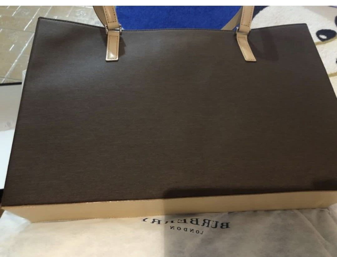 Burberry London Tote Bag (Category: Luxury Bags & Wallets) located in Cainta. Submitted by yummybunny06 (Listing ID 1432341448, Image 2). Description: - Burberry London tote bag - Brown patterned exterior - Beige leather handles and trim - Beige interior with multiple compartments - Includes dust bag.