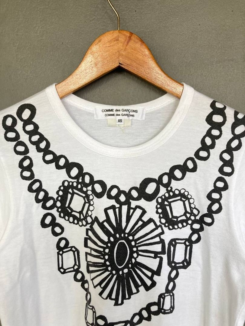 Comme des Garçons Necklace Print Tee (Category: Others Tops) located in Quezon City. Submitted by stylenpick (Listing ID 1432366388, Image 3). Description: Brand: Comme des Garçons Made in: Japan Material: Cotton Color: White Marked size: XS Sizing: Measurements (laid flat) Shoulders: 14” Sleeves: 6.5” Bust: 16.5” Hem: 18” Length: 22.5” Color rating: 8.5/10 Condition overall: 8.5/10 Flaws: light stain .