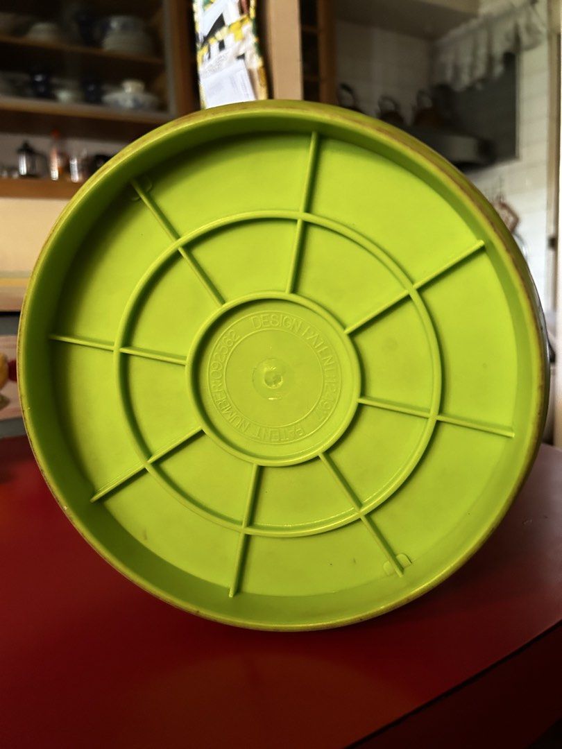 Disney Winnie the Pooh Storage Can (Category: Food Organization & Storage) located in Las Pinas. Submitted by rjmwings (Listing ID 1432255666, Image 3). Description: Winnie the Pooh-themed storage can. It features a green and yellow color scheme with illustrations of Winnie the Pooh, a butterfly, and clouds. It has a circular base and a cylindrical body. The bottom of the can has a design with the text "DESIGN PATENT APPLIED FOR". Can also be use