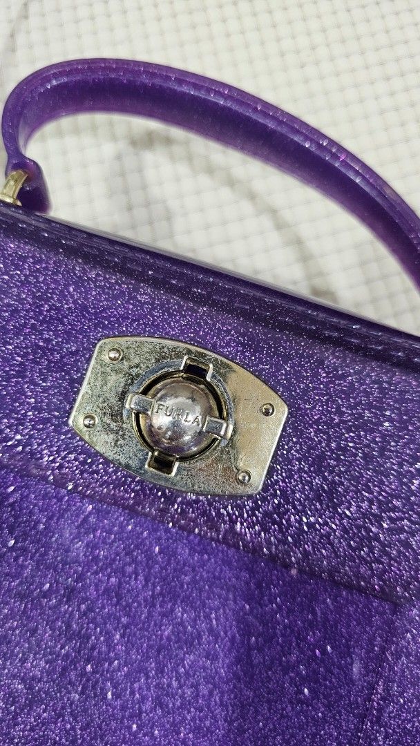 Furla Jelly Glitter Mini Sling Bag (Category: Luxury Bags & Wallets) located in Bulacan. Submitted by sossyfashion2013 (Listing ID 1432337985, Image 2). Description: - Furla mini sling bag - Sparkly purple glitter finish - Top handle and detachable shoulder strap - Silver-tone clasp closure - Compact size As seen in picture/s this bag has issue/s. Pls. do manage your expectation..