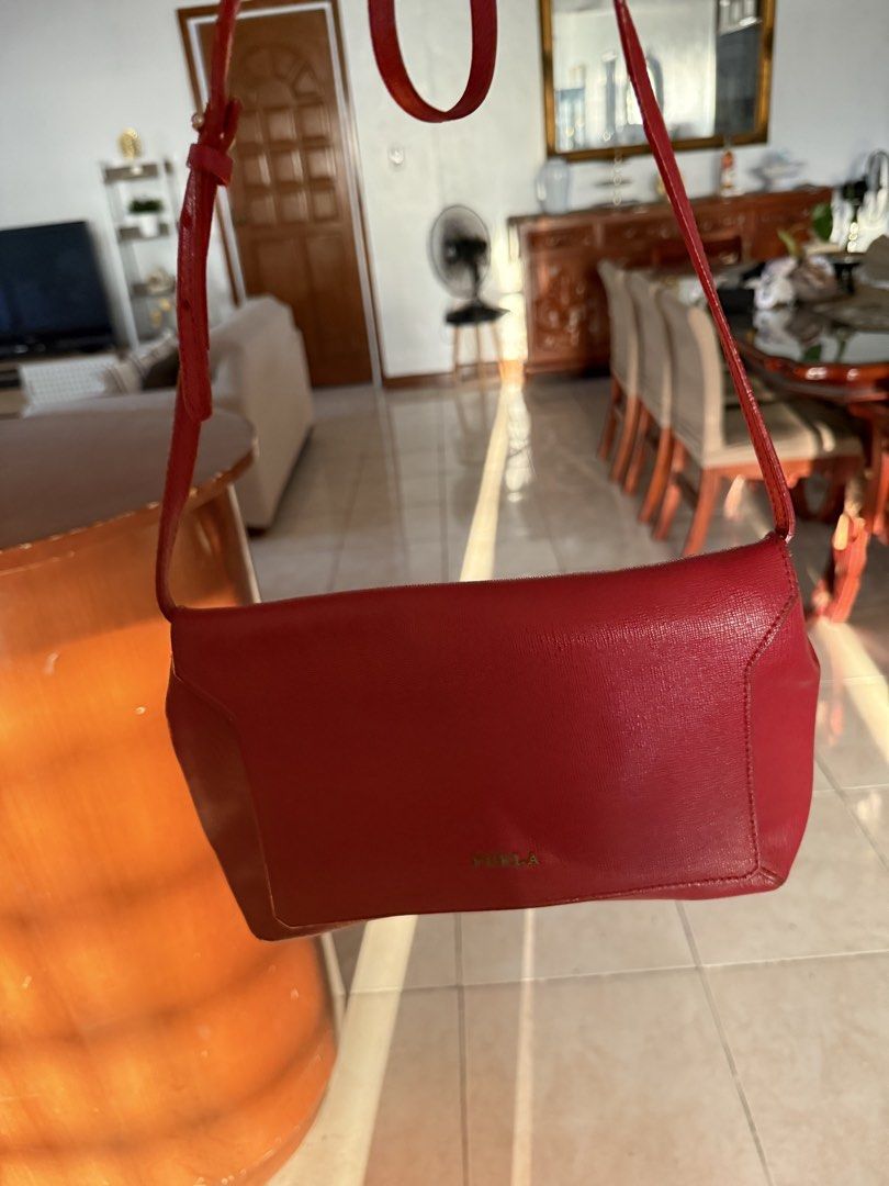 Furla Red Crossbody Bag (Category: Luxury Bags & Wallets) located in Quezon City. Submitted by myfavecloset11 (Listing ID 1432288591, Image 2). Description: - Red Furla crossbody bag - Flap closure with magnetic snap - Interior zippered pocket - Furla branded tag - Long, adjustable strap - w/ signs of wear on strap.